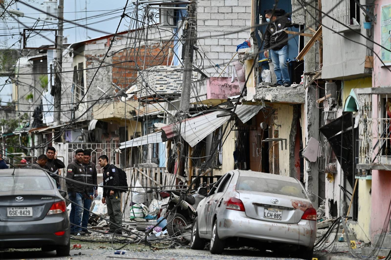 Miembros de la Policía Nacional inspeccionan el lugar de una explosión, que el gobierno ecuatoriano atribuye al crimen organizado, en el sur de Guayaquil, Ecuador, el 14 de agosto de 2022. Foto: AFP.